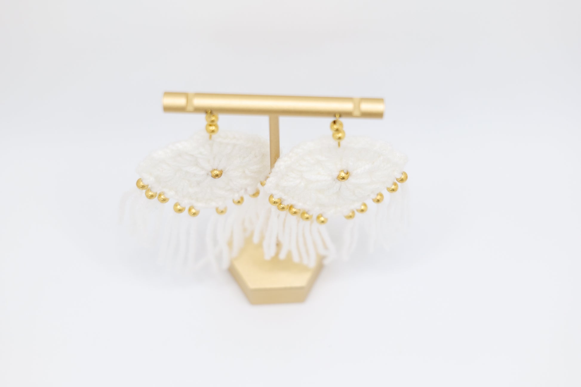 Crocheted tassel earrings with gold beads in white image 1